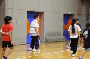 体育館で遊ぶ教育実習生と子どもたち