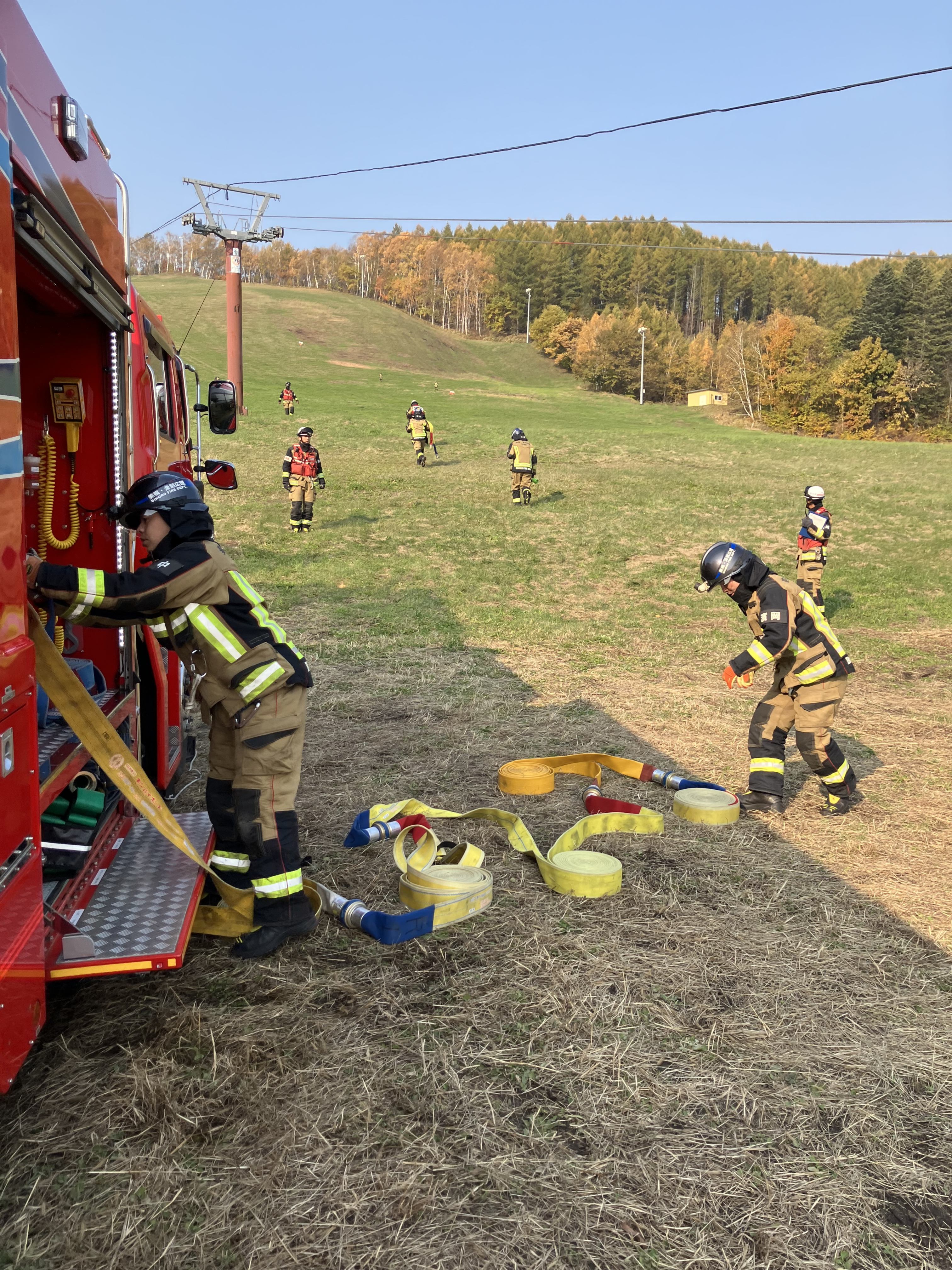 リリー山に向かってホースを延長する消防士