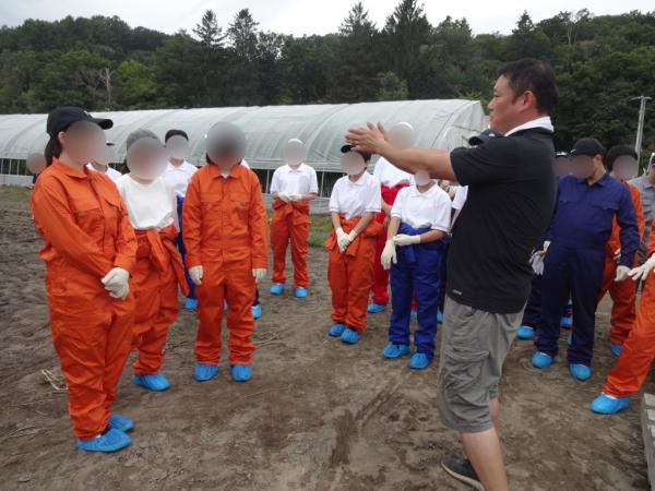 受入農家の説明を受ける生徒たち